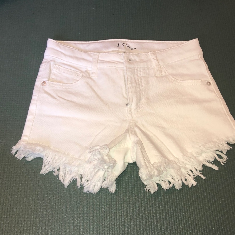 White jean shorts with fringe material.